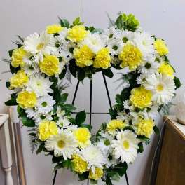 Heart-shaped floral wreath with white daisies and yellow carnations