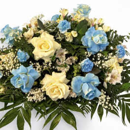 Large floral arrangement with blue and cream roses and small white filler flowers