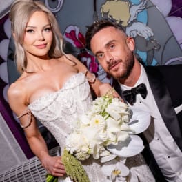 Bride holding a white bouquet beside a man in a tuxedo