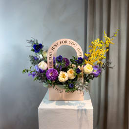 Mixed purple and cream flowers in a pink gift box with a circular "Just for You" topper