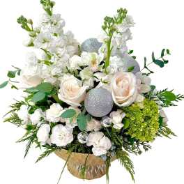 White floral arrangement with roses, orchids, and silver ornaments in a vase