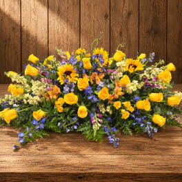 Large yellow and blue floral arrangement on a wooden table