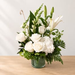 White roses and lilies arranged in a glass vase