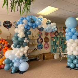 Blue and white balloon arch in a party room