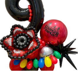 Stranger Things-themed balloon arrangement with a large black 9 and red balloons