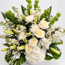 White floral arrangement with roses, lilies, and chrysanthemums in a white vase