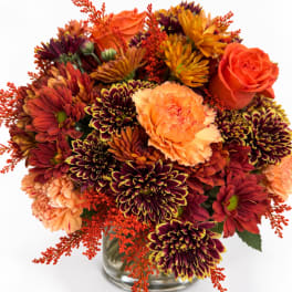 Orange roses and burgundy chrysanthemums in a glass vase