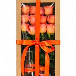 Boxed bouquet of peach and pink roses with an orange ribbon