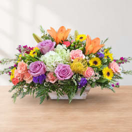 Colorful mixed flower arrangement in a low rectangular container