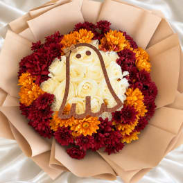 Round bouquet of cream roses and burgundy-orange chrysanthemums with a bell topper