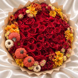 Bouquet of red roses with yellow and orange chrysanthemums and small decorative pumpkins