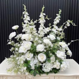Large white floral arrangement with roses and tall branching blooms