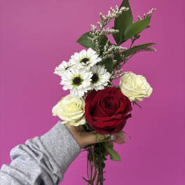 Handheld bouquet with red and cream roses and white daisies