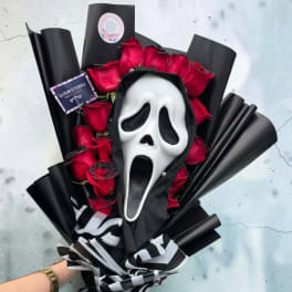 Bouquet of red roses with a white Ghostface mask and black wrapping.