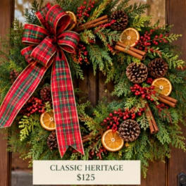 Christmas wreath with plaid bow, pinecones, oranges, and cinnamon sticks