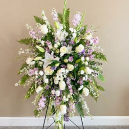 Tall white and lavender floral standing spray on a black easel