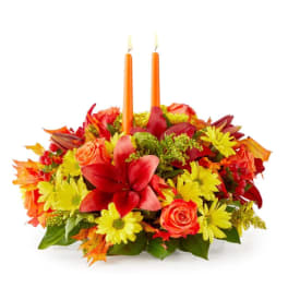 Autumn floral centerpiece with two orange candles
