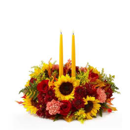 Autumn floral centerpiece with two yellow taper candles