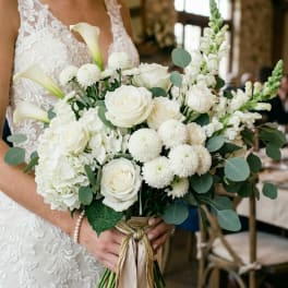 White bridal bouquet with roses, calla lilies, and snapdragons
