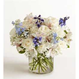 White and blue mixed bouquet in a clear glass vase