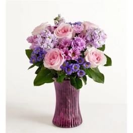Pink and purple flower arrangement in a tall purple vase