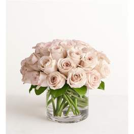Pale pink roses arranged in a clear glass vase