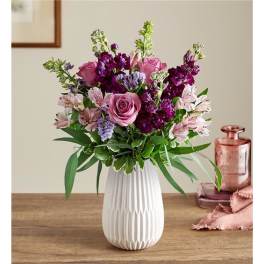 Pink and purple flower arrangement in a white vase