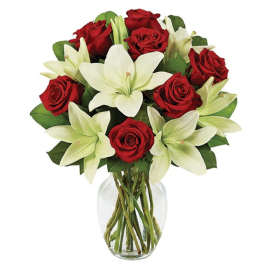 Red roses and white lilies arranged in a clear glass vase