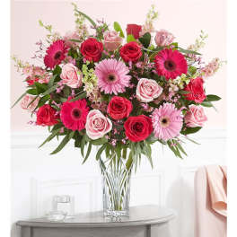 Pink and red rose bouquet with gerbera daisies in a clear glass vase