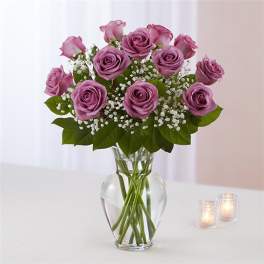Pink roses arranged in a clear glass vase with baby's breath