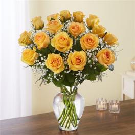 Yellow roses arranged in a clear glass vase with baby's breath