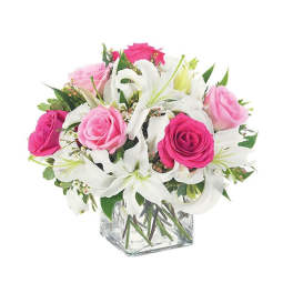 Pink and white roses with lilies in a clear square vase