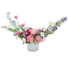 Pink and lavender flower arrangement in a white vase