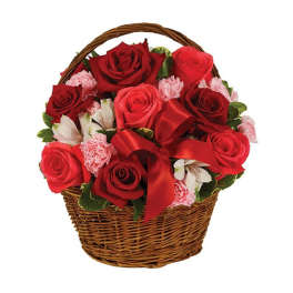 Red roses and pink carnations in a wicker basket with a red ribbon