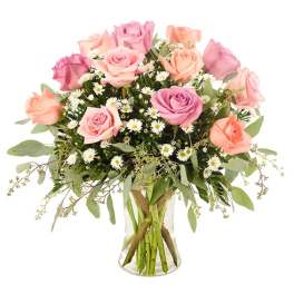 Pink and peach roses arranged in a clear glass vase with small white daisies.