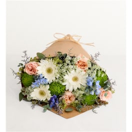 Mixed bouquet with white daisies, peach roses, and blue flowers in kraft wrap