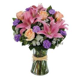 Pink lilies and peach roses in a clear glass vase