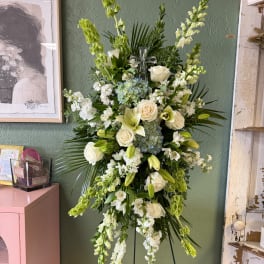 Tall white and green floral standing spray with roses and lilies