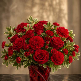 Red roses and carnations in a red glass vase