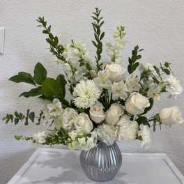 White floral arrangement in a ribbed silver vase
