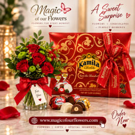 Red roses in a glass vase beside a red chocolate gift box