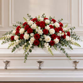 Red and white rose casket spray with eucalyptus and white filler flowers