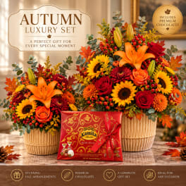 Two autumn flower baskets with a box of chocolates in front