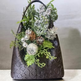 Decorative holiday basket with glittery greenery, pinecones, and silver ornaments