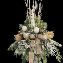 Winter holiday arrangement with pinecones, ornaments, and a burlap bow