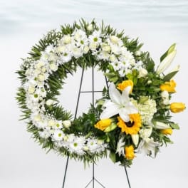 White and yellow floral wreath on a stand