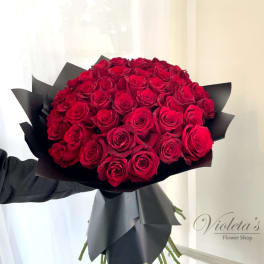 Large bouquet of red roses wrapped in black paper