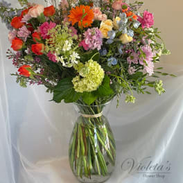 Colorful mixed bouquet in a clear glass vase with tall stems