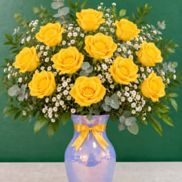 Yellow roses in a blue vase with baby's breath