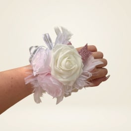 Wrist corsage with white and pale pink roses and ribbon accents
